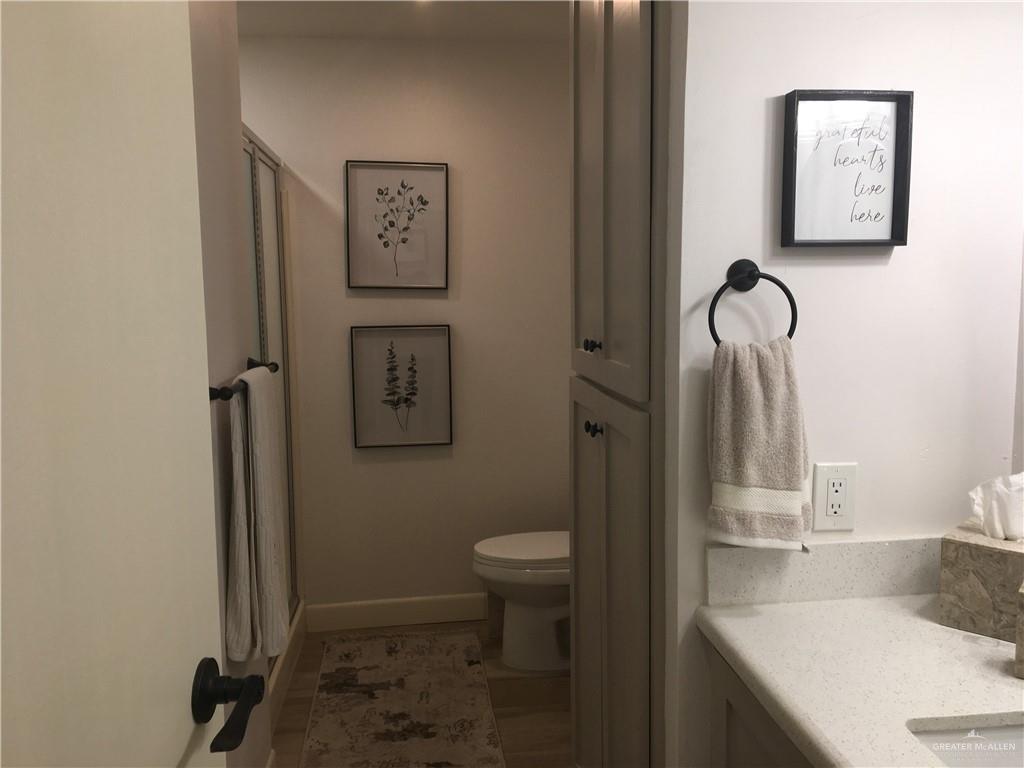 700 Fern Street, Unit 5 McAllen, TX 78504 - Photo 10 of 22 a bathroom with a granite countertop toilet sink and mirror