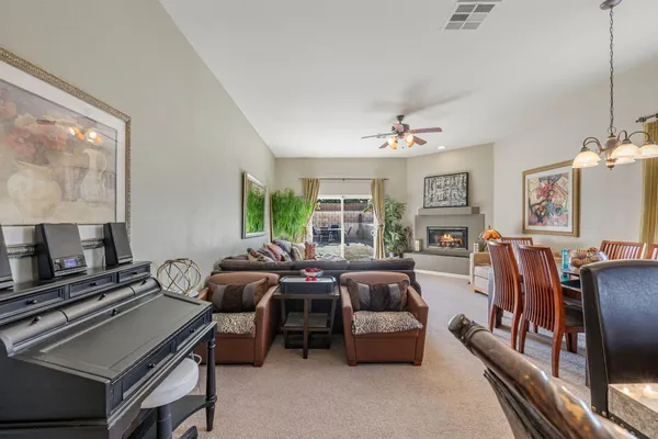 a living room with furniture ceiling fan and a window