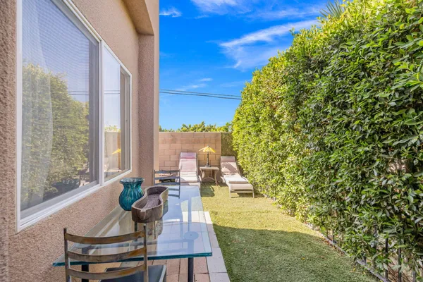 a patio with table and chairs and potted plants