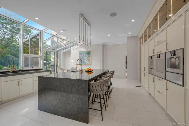 a kitchen with stainless steel appliances kitchen island granite countertop a table and chairs in it