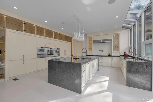 a large white kitchen with lots of counter space and window