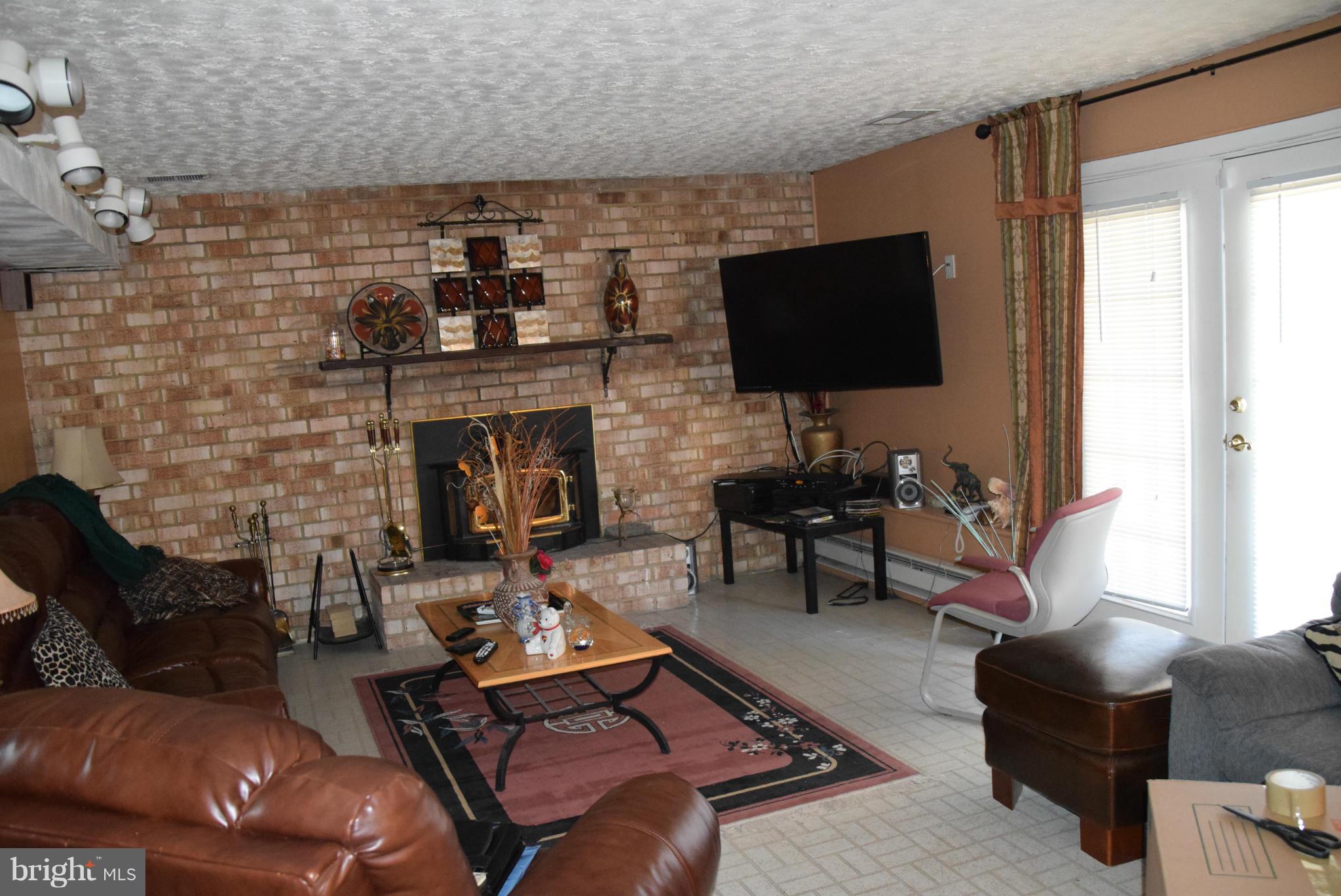 4012 Winlee Road Randallstown, MD 21133 - Photo 16 of 22 a living room with furniture a flat screen tv and a fireplace