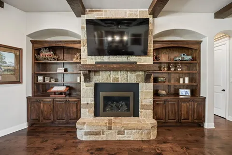 a living room with furniture a flat screen tv and a fireplace