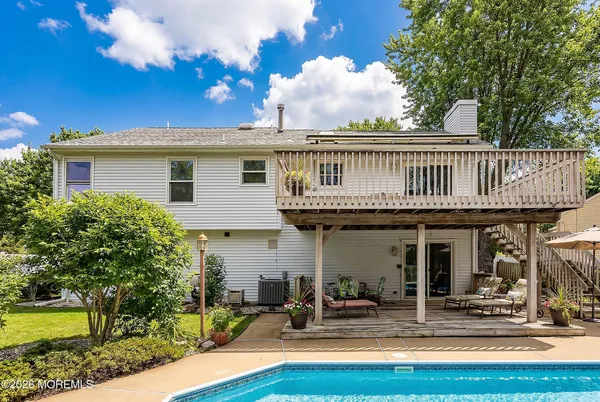 a front view of a house with swimming pool and furniture