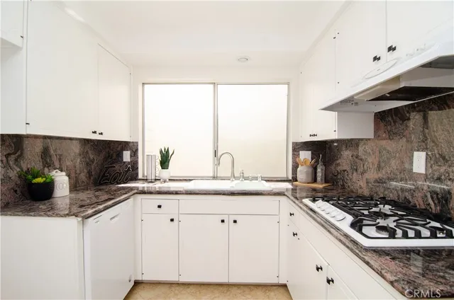 a kitchen with stainless steel appliances granite countertop a sink stove and cabinets