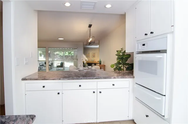 a kitchen with granite countertop white cabinets and white appliances