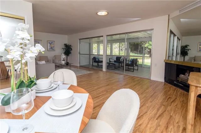 a dining room with furniture a rug potted plants and wooden floor