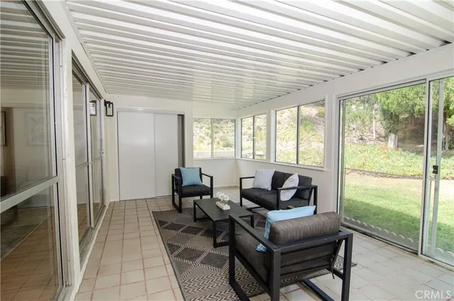 a living room with furniture and a floor to ceiling window