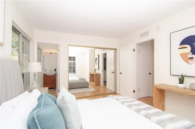 a spacious bedroom with a bed and glass walk in closet