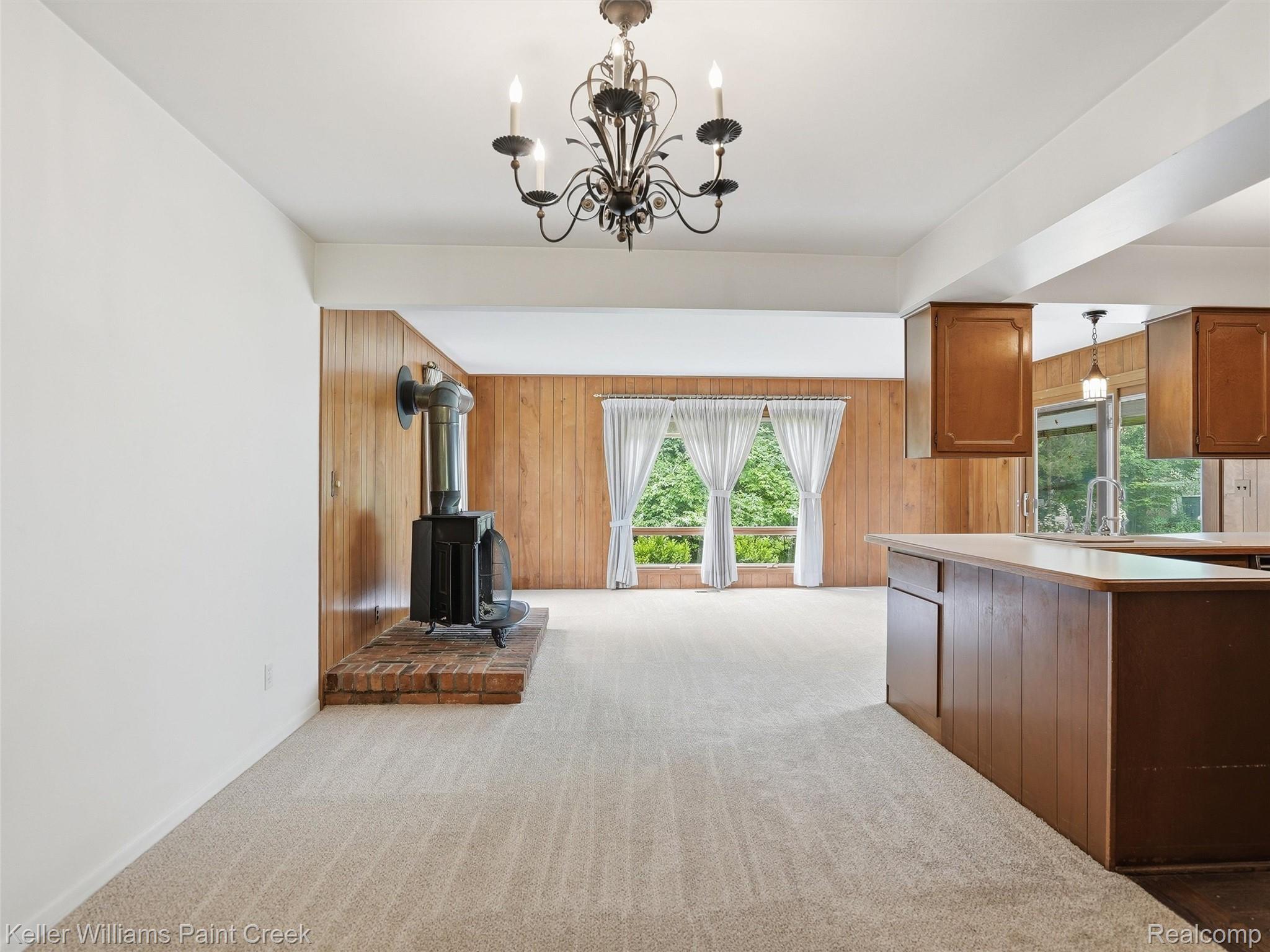 436 Broadleaf Drive Rochester, MI 48306 - Photo 13 of 41 Kitchen featuring wood finish cabinets, light carpet, light countertops, wooden walls, and hanging lights