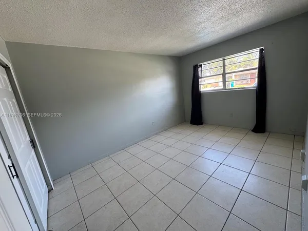 an empty room with fan and entrance