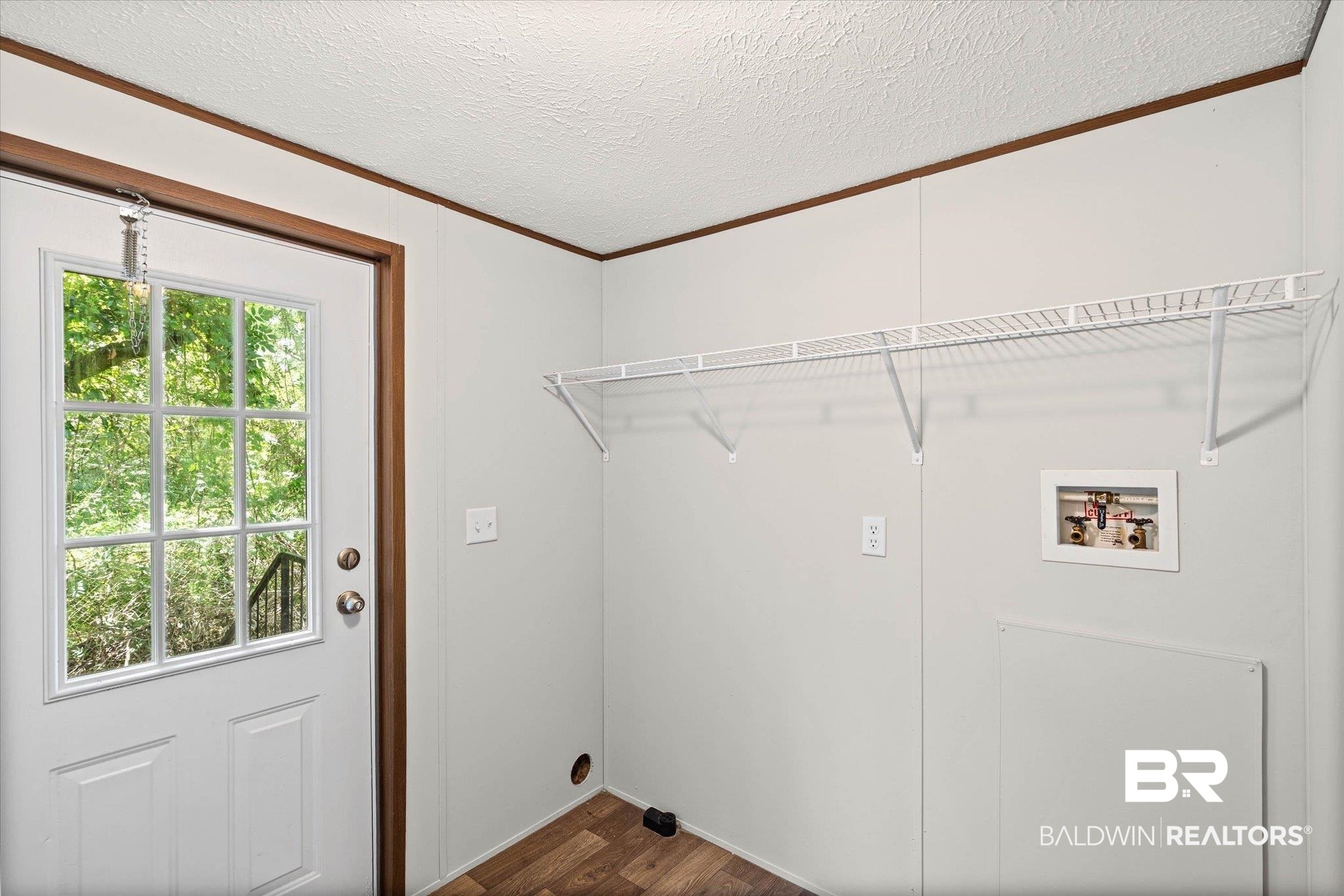 25366 Pollard Road Daphne, AL 36526 - Photo 19 of 22 Utility area featuring wood-finish flooring, white paneled walls, and a white wire shelving unit