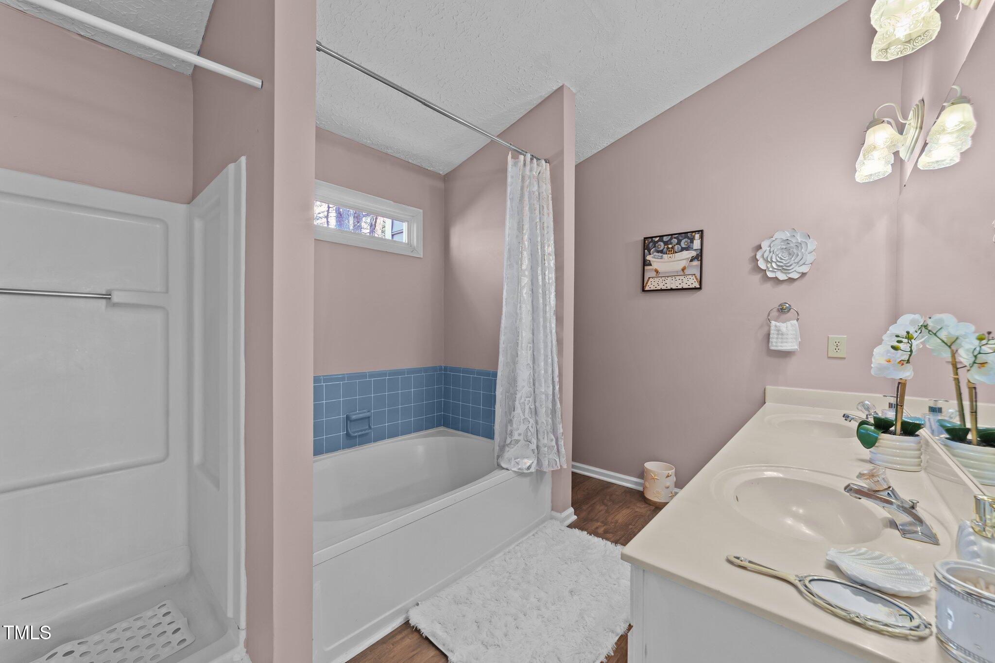 300 Pate Street Apex, NC 27502 - Photo 19 of 38 a bathroom with a tub shower and a sink