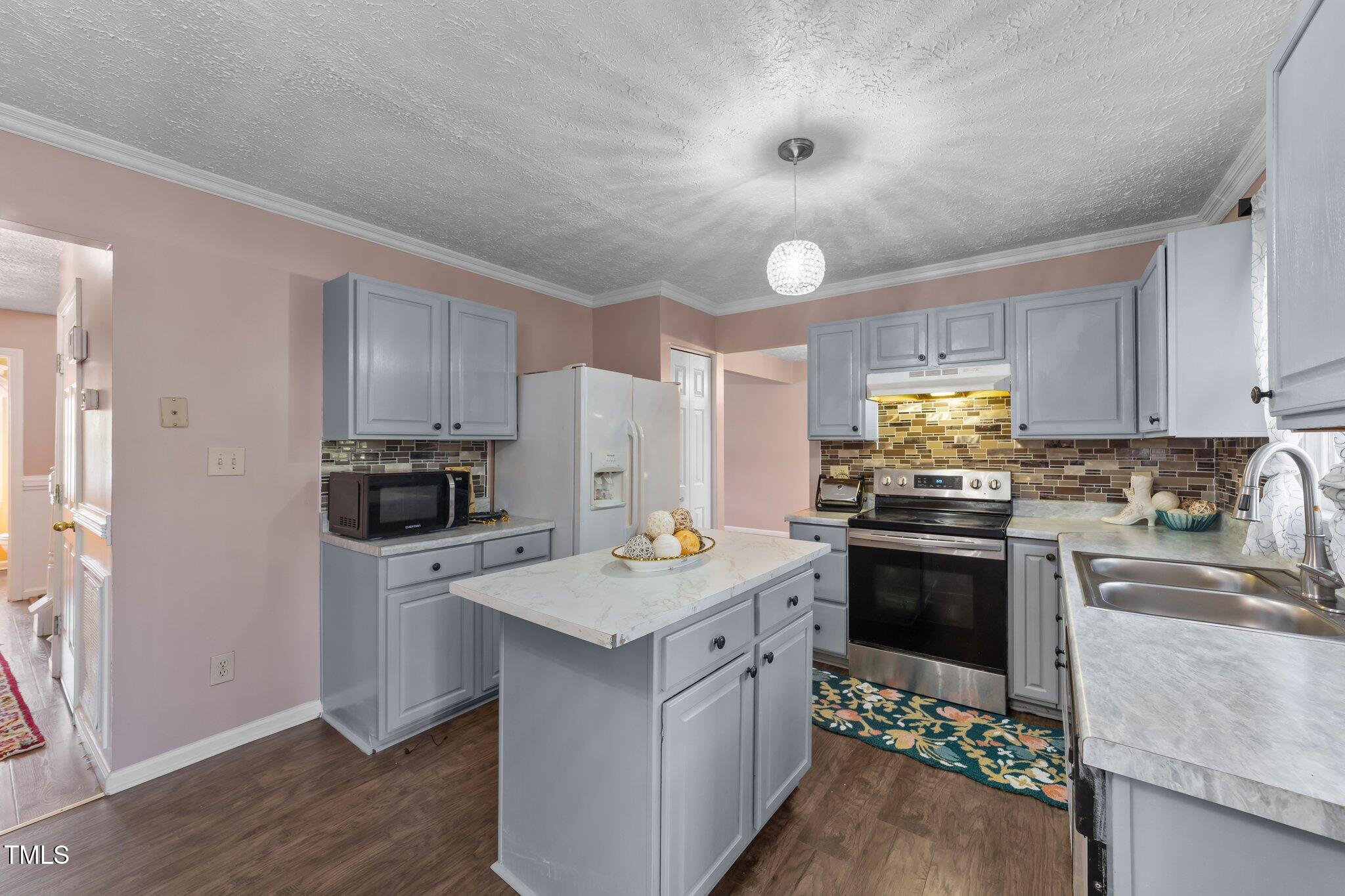 300 Pate Street Apex, NC 27502 - Photo 3 of 38 a kitchen with stainless steel appliances granite countertop a sink stove microwave and refrigerator