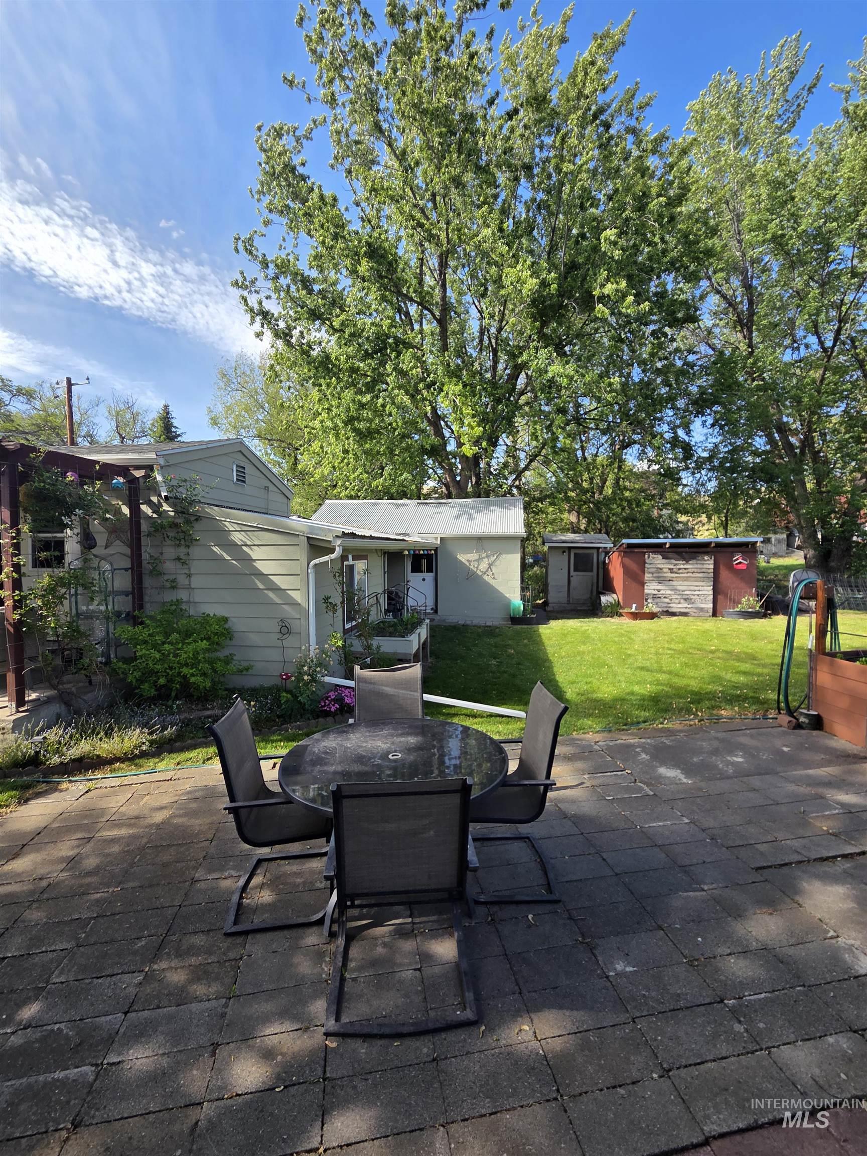 109 South 3rd Street Pomeroy, WA 99347 - Photo 35 of 36 Expansive paved patio area featuring a pergola structure and lush greenery