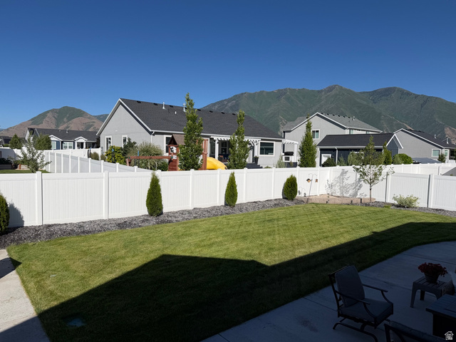 315 South Sherman Street Mapleton, UT 84664 - Photo 27 of 30 Expansive backyard with a manicured lawn, established landscaping, and a surrounding white privacy fence