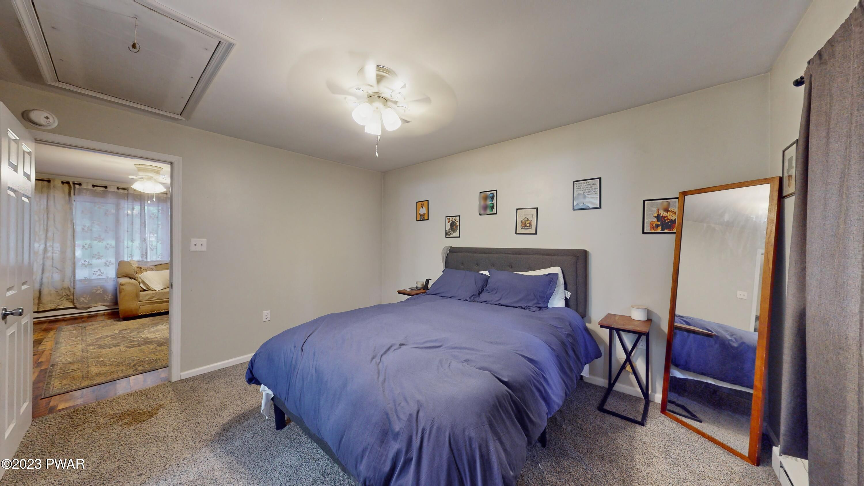 149 Walker Lake Road Shohola, PA 18458 - Photo 33 of 51 a bedroom with a large bed and a chandelier