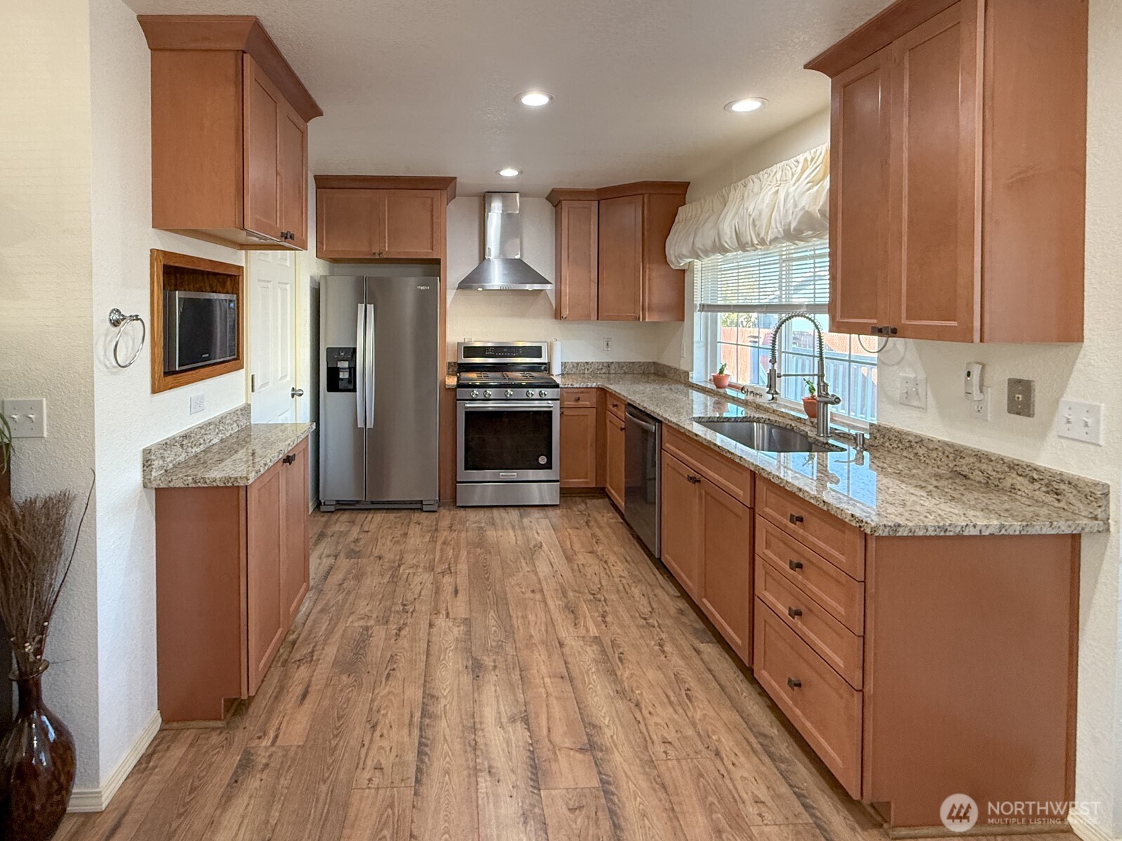 823 Southwest 21st Street Chehalis, WA 98532 - Photo 16 of 38 a kitchen with stainless steel appliances granite countertop a stove a sink dishwasher a refrigerator and a oven with wooden floor