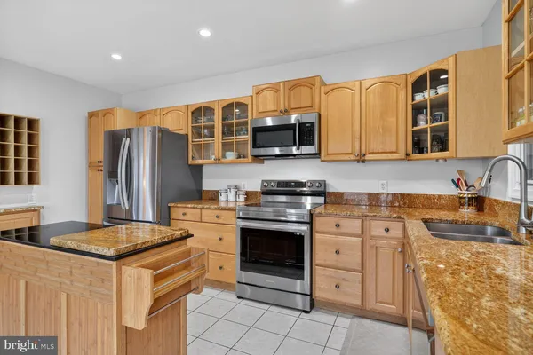 a kitchen with stainless steel appliances granite countertop a stove sink and cabinets