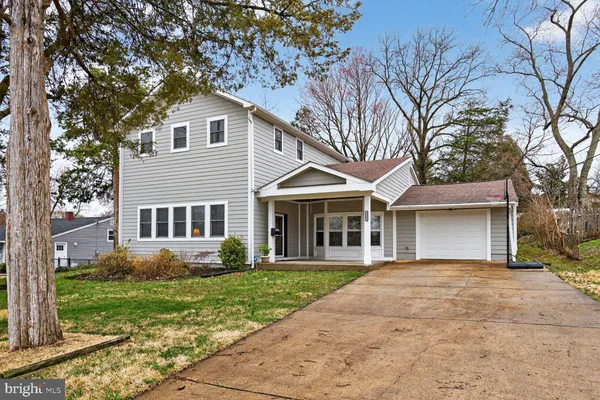 a front view of a house with a yard and trees