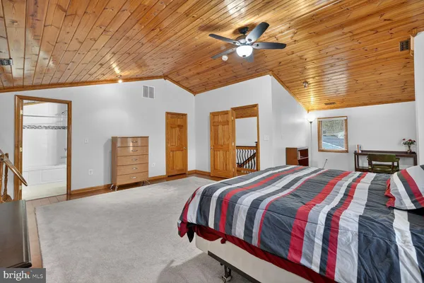 a bed sitting in a spacious bedroom next to a window