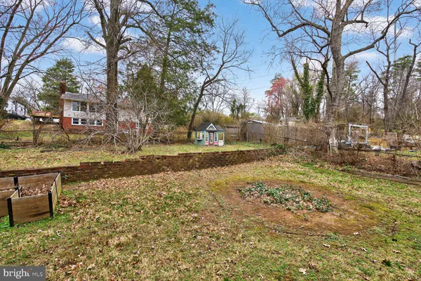 a view of a house with a yard and large tree