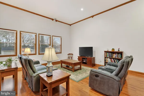 a living room with furniture a flat screen tv and a floor to ceiling window