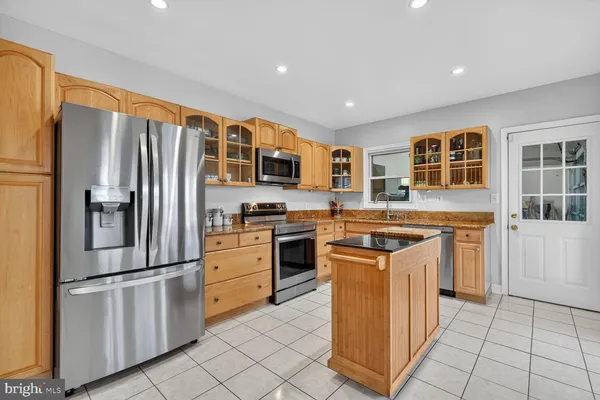 a kitchen with stainless steel appliances granite countertop a stove top oven and refrigerator