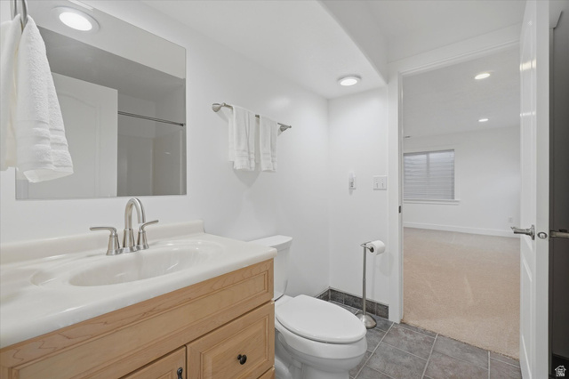 791 East Saddle Road Grantsville, UT 84029 - Photo 32 of 46 Bathroom featuring a light wood vanity, white countertop with integrated sink, brushed nickel faucet, large wall mirror, and recessed lighting