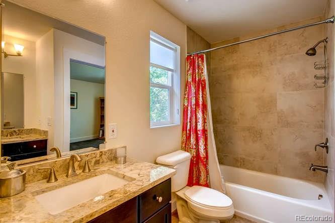 810 East Baseline Road, Unit B Lafayette, CO 80026 - Photo 22 of 28 a bathroom with a granite countertop sink toilet a shower and a mirror