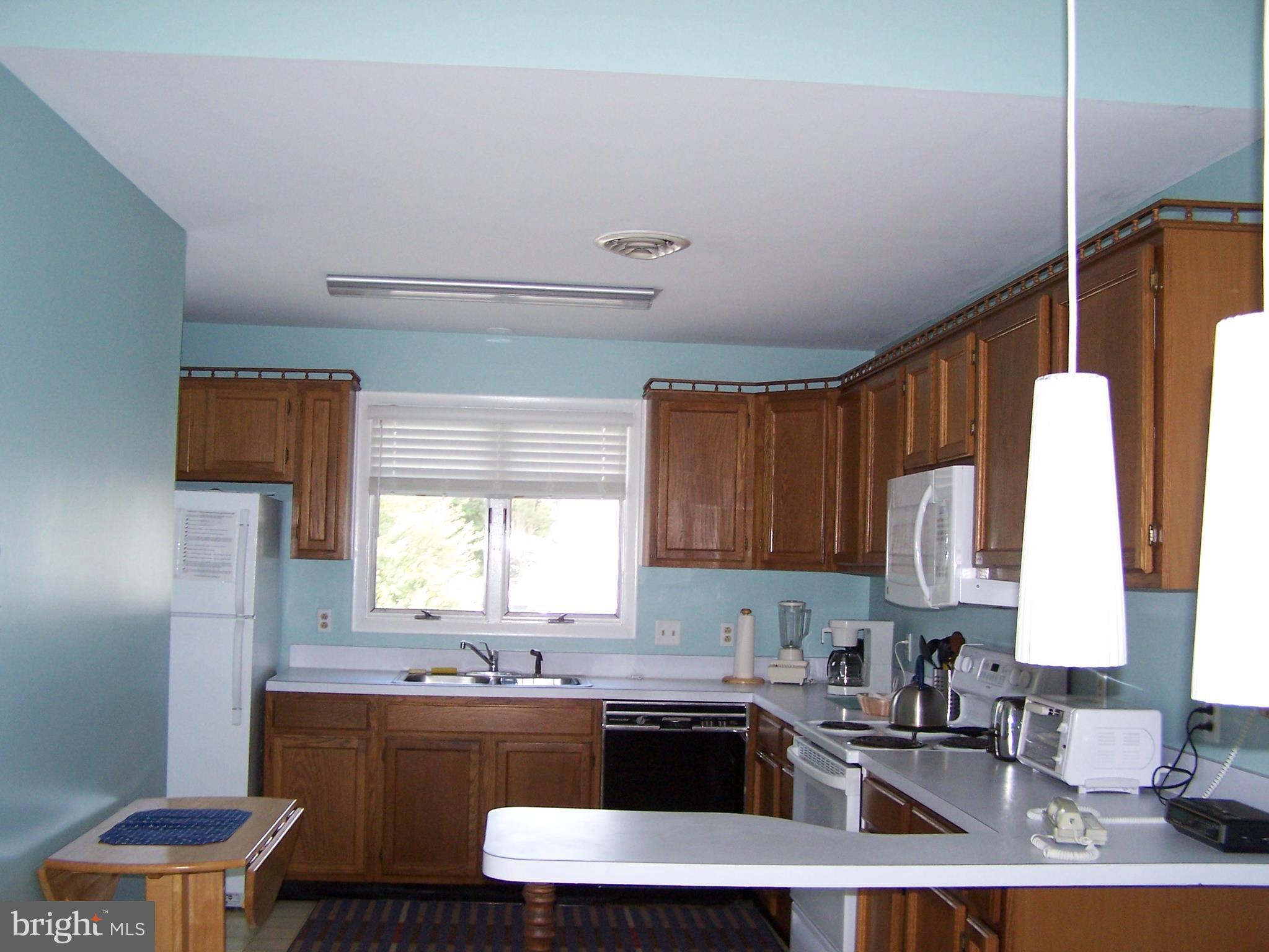 1402 Cedar Street Lewes, DE 19958 - Photo 3 of 6 a kitchen with a sink a stove a refrigerator and cabinets