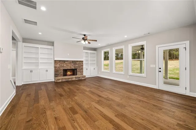 a view of an empty room with a fireplace and a window