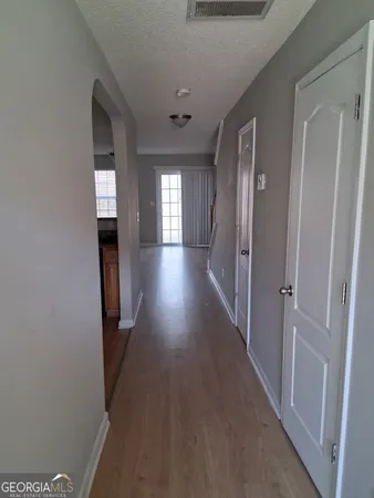 a view of a hallway with wooden floor and staircase