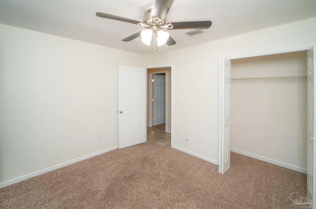 an empty room with a ceiling fan and a fan