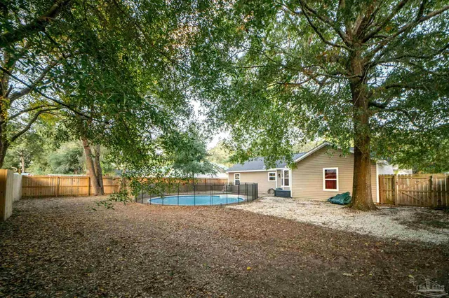 a view of a house with a backyard and a tree