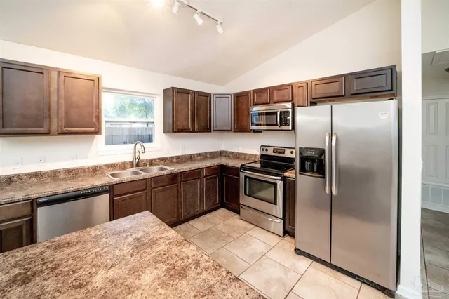 a kitchen with granite countertop a refrigerator and a sink