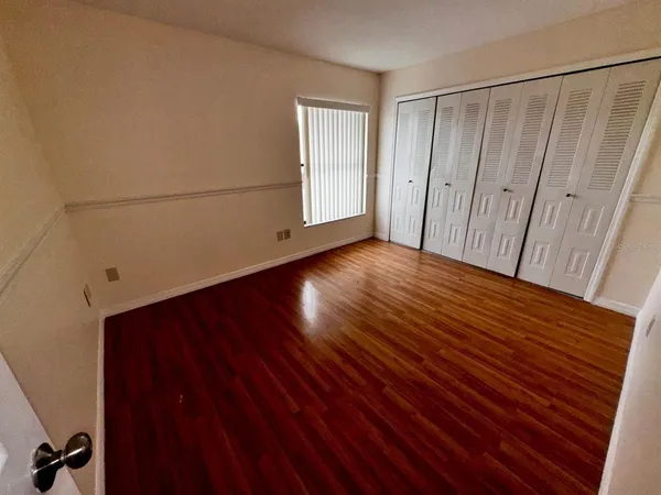 a view of an empty room with wooden floor