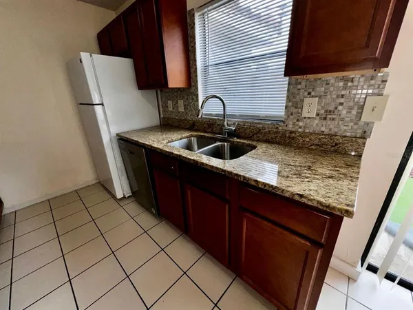 a kitchen with a sink a stove top oven and cabinets