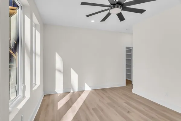 a kitchen that has a lot of white cabinets and wooden floor