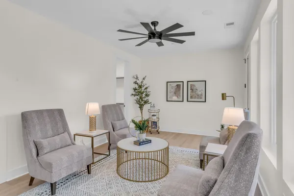 a living room with furniture and a wooden floor
