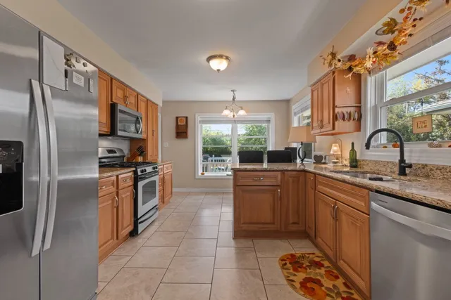 a kitchen with stainless steel appliances granite countertop a sink stove and refrigerator