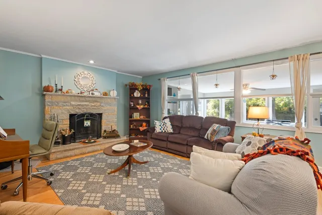 a living room with furniture a fireplace and a large window