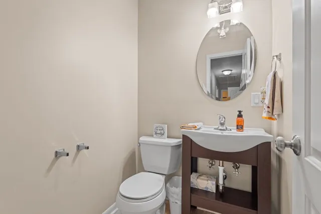 a bathroom with a toilet a sink and mirror
