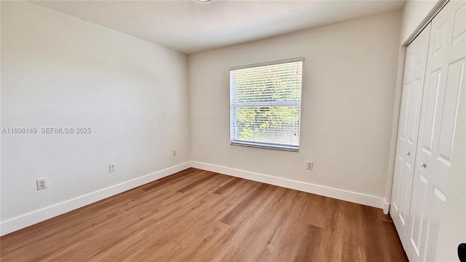 13843 Southwest 31st Street Miramar, FL 33027 - Photo 32 of 58 an empty room with wooden floor and windows