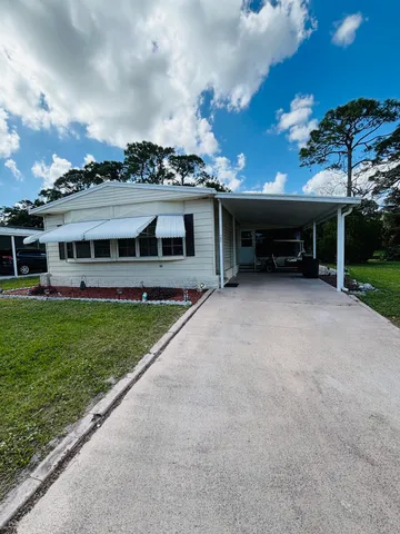 a view of a house with a yard and sitting area