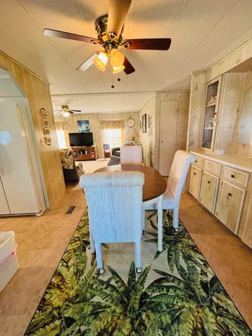 a view of a dining room with furniture a rug and wooden floor