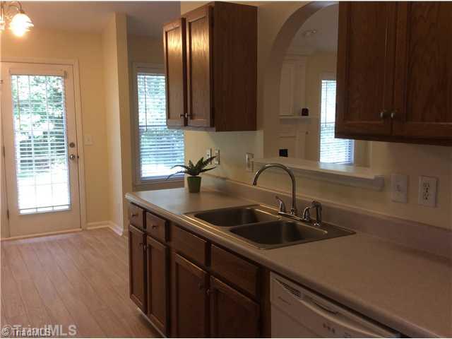 7502 Keating Drive Oak Ridge, NC 27310 - Photo 6 of 16 Kitchen. Kitchen with pass through nicely opens the space! French doors open out to the wooded backyard.
