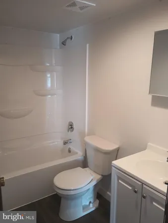 a white toilet sitting next to a bath tub