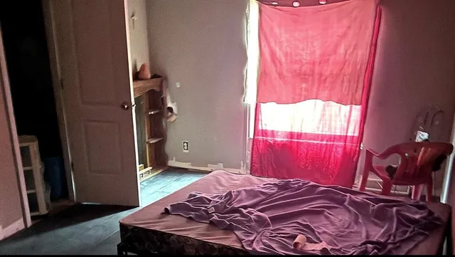 a bed sitting in a bedroom next to a window