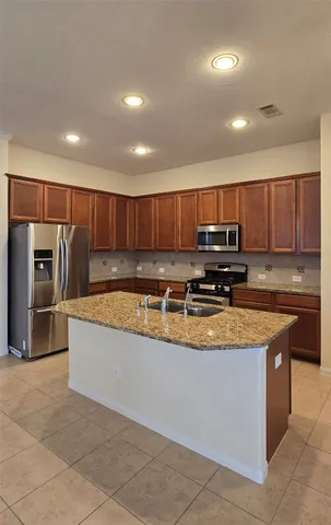 a large kitchen with stainless steel appliances and a refrigerator